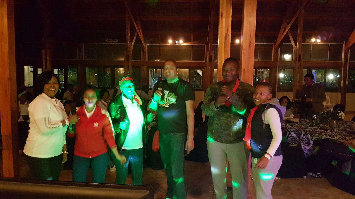Colleagues singing karaoke together at an evening corporate function