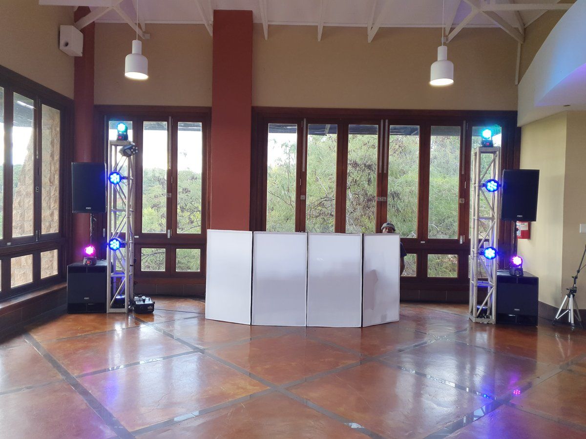 DJ booth with truss lighting and speakers set up on a venue dance floor
